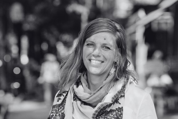 Bianca Klose, Geschäftsführerin des Vereins für demokratische Kultur in Berlin e.V. und Gründerin der Mobilen Beratung gegen Rechtsextremismus Berlin (MBR), im Porträt. Schwarz-weiß-Fotografie im Querformat, im Hintergrund Bäume einer Grünanlage. (c) Peter van Heesen/MBR 